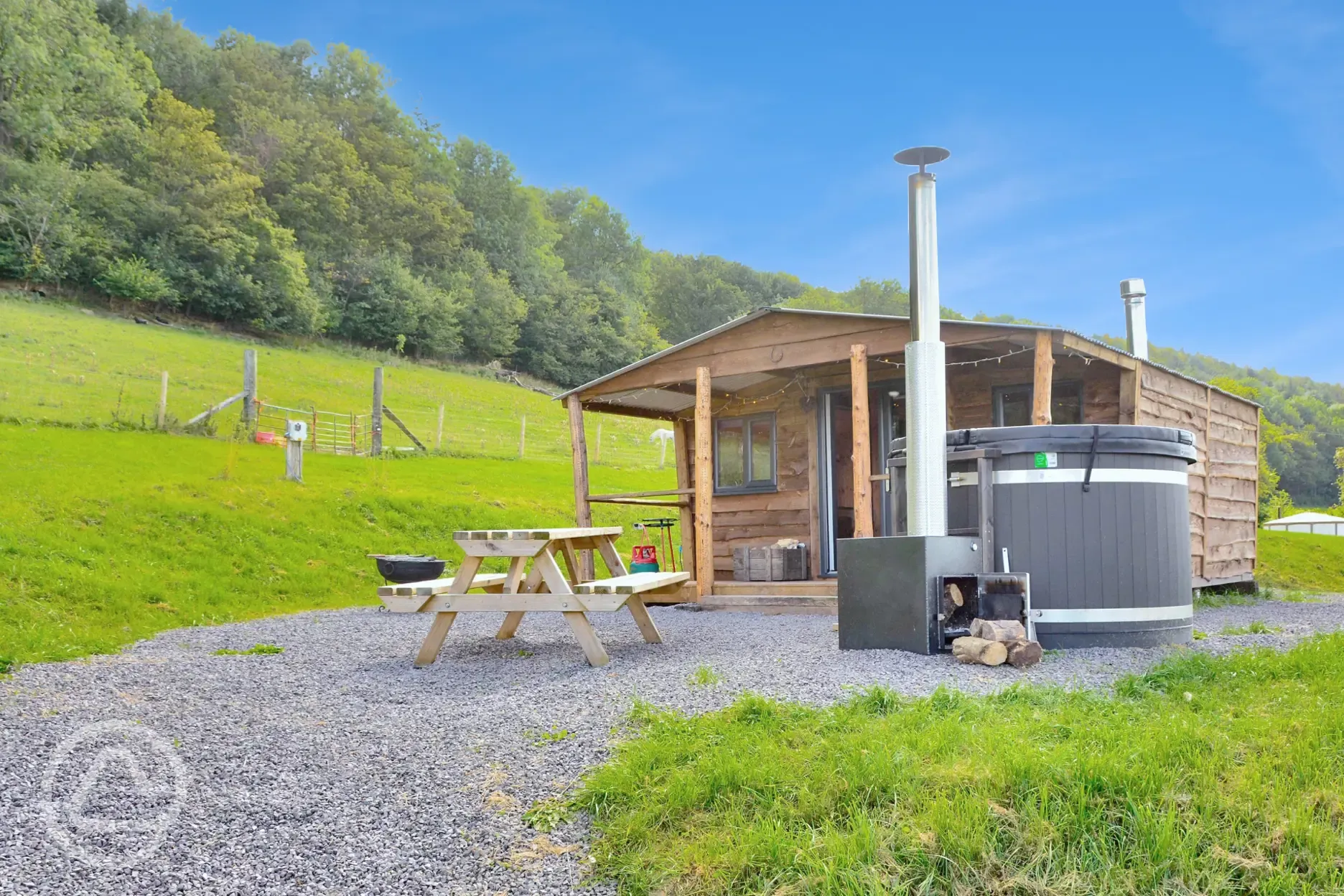 Caradoc Lodge with a wood-fired hot tub and picnic bench
