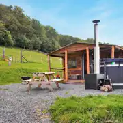 Caradoc Lodge with a wood-fired hot tub and picnic bench at Lower Hill Campsite