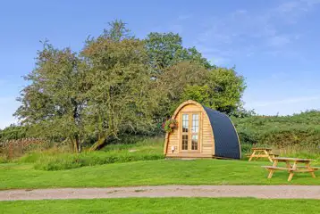 Camping pod exterior with outdoor seating, sleeping up to three
