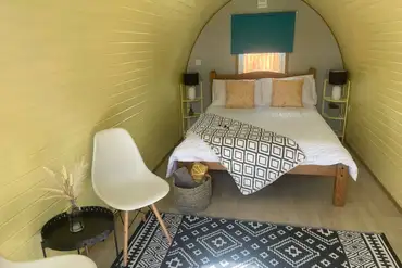 Camping pod with a double bed and bedding