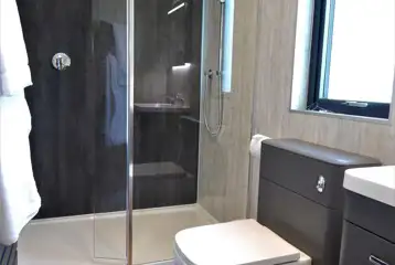Ensuite glamping lodge bathroom with rainfall shower (towels and robes provided)
