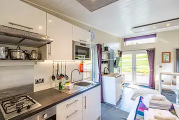 Merlin's Cabin kitchen with a hob, kettle, sink, fridge and microwave Merlin's Cabin kitchen with a hob, kettle, sink, fridge and microwave