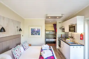 Merlin's Cabin interior with a double bed and bunk beds (bedding provided) Merlin's Cabin interior with a double bed and bunk beds (bedding provided)
