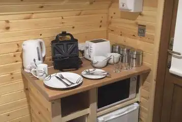 Log pod kitchenette with a kettle, microwave, toaster and fridge Log pod kitchenette with a kettle, microwave, toaster and fridge