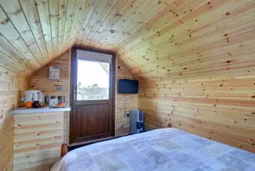 Log pod interior with tv, kitchenette and an electric heater. Log pod interior with tv, kitchenette and an electric heater.