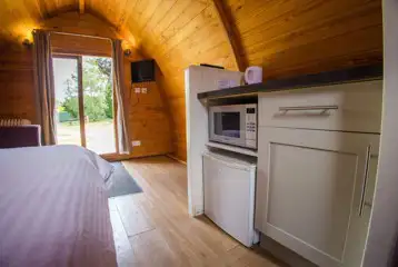 Camping mega pods mini kitchen with a fridge, microwave and kettle