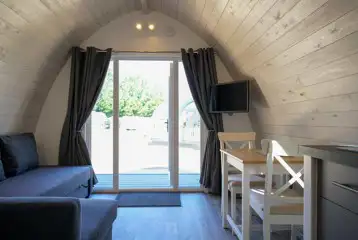 Elite pod dining area and sofa with a TV