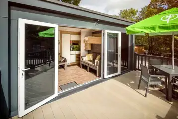 Glamping pod with an outdoor deck area and seating