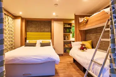 Glamping pod interior with a double sofa bed and bunk beds