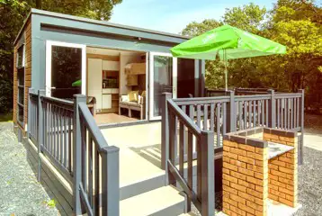 Ensuite glamping pods accessed by a small set of stairs with a brick BBQ