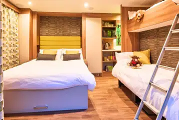 Ensuite glamping pod interior with a double sofa bed, single sofa bed and bunk