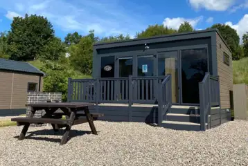 Ensuite glamping pod with a raised decking and outdoor picnic bench