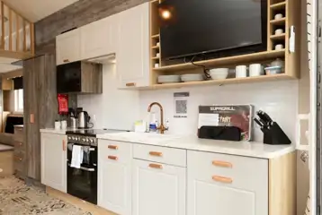 Glamping cabin kitchen with a kettle, toaster, microwave, oven and fridge