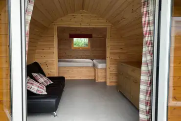 Camping pod interior with a small double bed and single bed