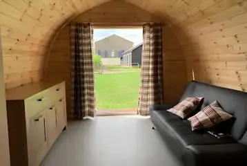 Camping pod interior with a double sofa and storage space Camping pod interior with a double sofa and storage space