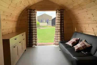 Camping pod interior with a double sofa and storage space
