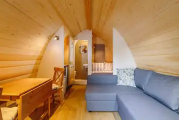 Ensuite glamping pod dining area and an L-shape sofa 