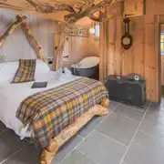 Whisky Howf Cabin interior with a king size bed and slipper bath Whisky Howf Cabin interior with a king size bed and slipper bath