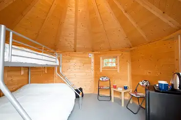 Camping cabin with a triple bunk bed and fold-away single camp bed