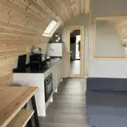 Mega ensuite glamping pod interior with a sofa bed, double bed and kitchen Mega ensuite glamping pod interior with a sofa bed, double bed and kitchen