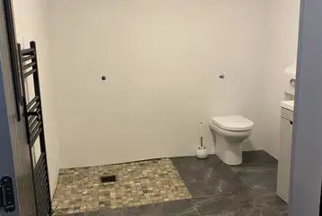 Family washroom with spacious shower and towel railing Family washroom with spacious shower and towel railing