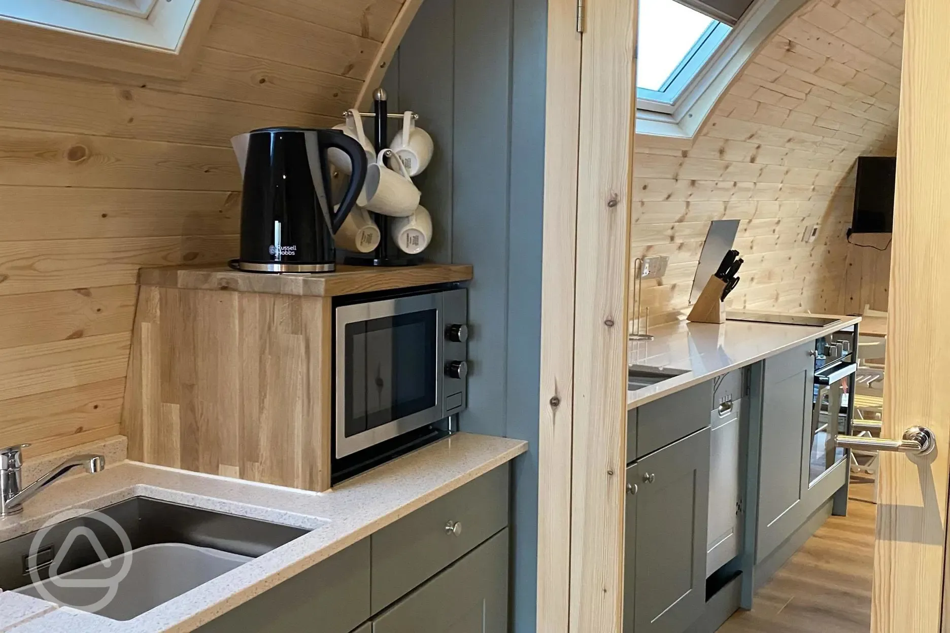 Mega ensuite glamping pod kitchen area with microwave, kettle, and crockery