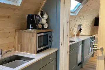 Mega ensuite glamping pod kitchen area with microwave, kettle, and crockery Mega ensuite glamping pod kitchen area with microwave, kettle, and crockery