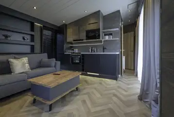 Glamping S-pod living area with sofa, kitchen and TV
