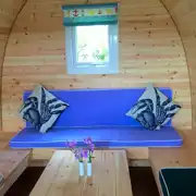 Camping pod (four person) interior with wrap around seating converting into beds Camping pod (four person) interior with wrap around seating converting into beds