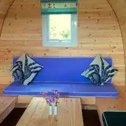 Camping pod (four person) interior with wrap around seating converting into beds