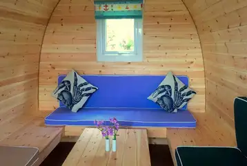 Camping pod (four person) interior with wrap around seating converting into beds