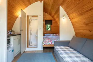 Bunny ensuite glamping pod interior with a double bed and sofa bed Bunny ensuite glamping pod interior with a double bed and sofa bed