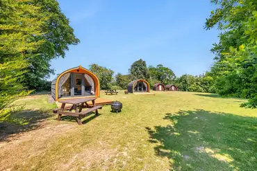 Glamping pods exterior with picnic tables and fire pits