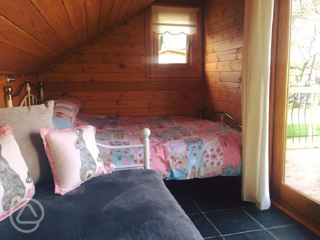 Mini lodge pod interior with seating and double bed