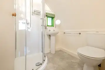 Bare Bones ensuite with a toilet, shower, sink and shaver socket