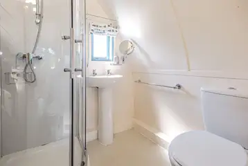 The Wheatley's ensuite with a toilet, shower, sink and shaver socket