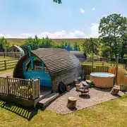 The Wheatley's glamping pod with a fire pit, seating and optional hot tub