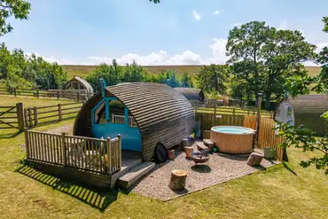The Wheatley's glamping pod with a fire pit, seating and optional hot tub