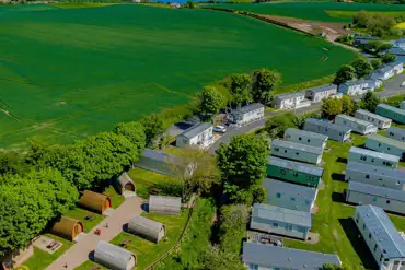 Aerial of Scoutscroft Leisure Park with the camping pods and coastal views