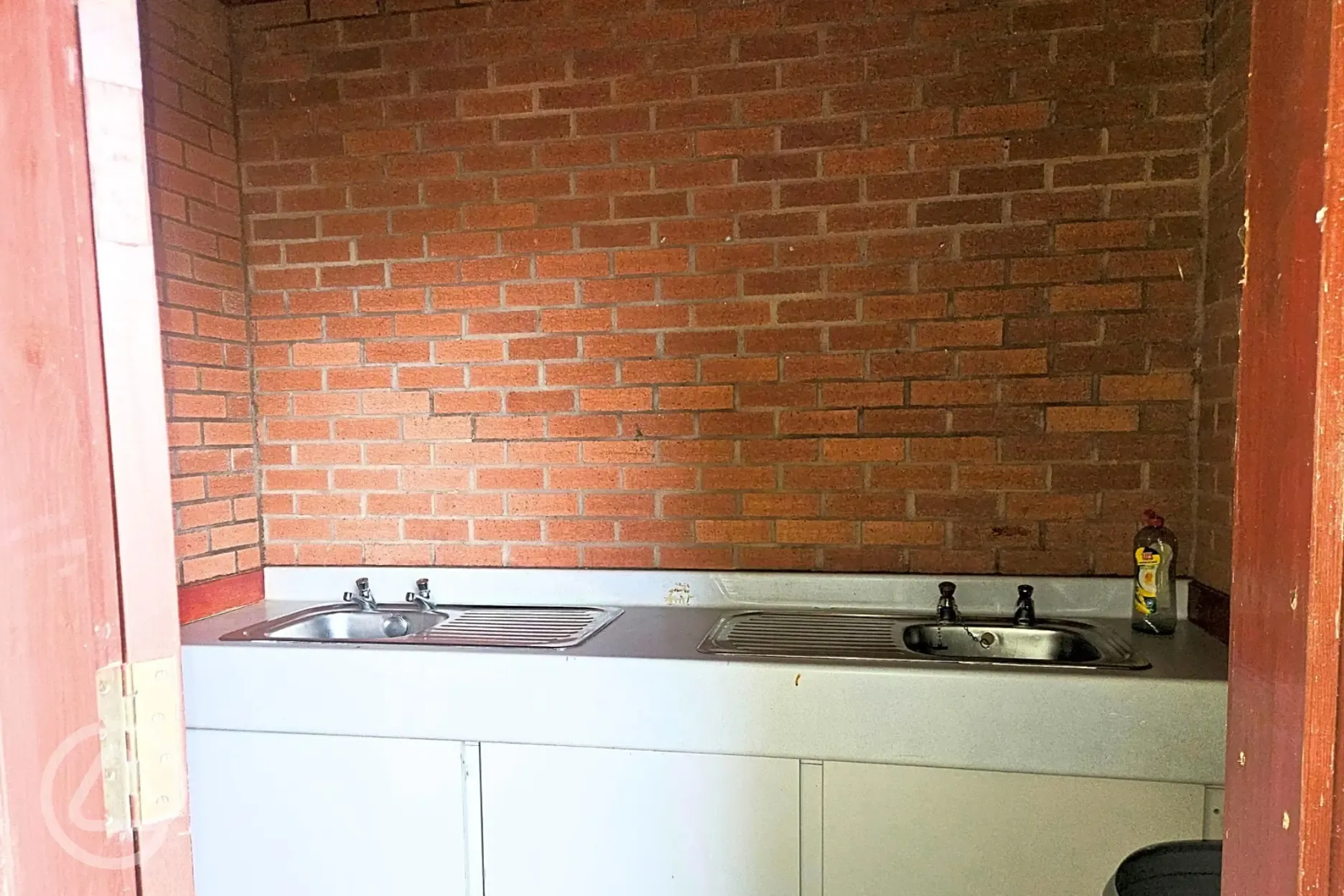 Sheltered outdoor washing up area with draining board space