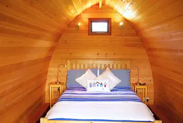 Posh Pod interior with a double bed, kitchenette, electric and more