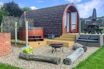 Ensuite glamping pods outdoor area with a fire pit, seating and hot tub Ensuite glamping pods outdoor area with a fire pit, seating and hot tub