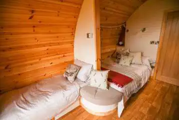 Glamping pod interior with a double bed and single sofa beds Glamping pod interior with a double bed and single sofa beds