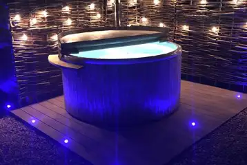 Ensuite glamping pod hot tub at night with fairy lights Ensuite glamping pod hot tub at night with fairy lights