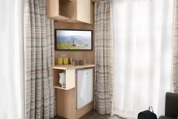 Studio pod cabin living area TV with a stored mini-fridge, kettle and crockery Studio pod cabin living area TV with a stored mini-fridge, kettle and crockery