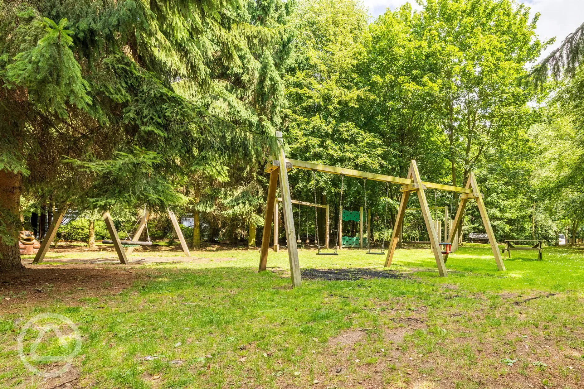 Children's play area with swings and climbing frames at Nurseries Caravan Park