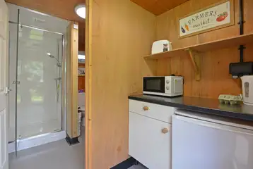 Pod private kitchen area with a microwave, fridge and fridge/freezer