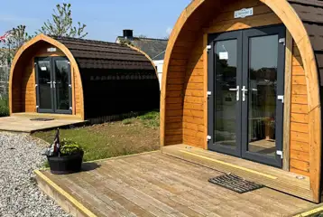 Wooden camping pods with small deck areas and glass doors Wooden camping pods with small deck areas and glass doors