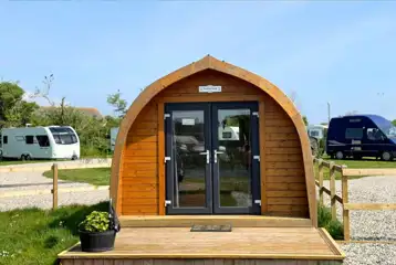 Wooden camping pod with a small deck area and glass doors Wooden camping pod with a small deck area and glass doors
