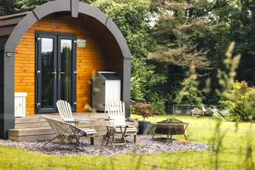 Cross Fell pod exterior with fire pit and outdoor seating at Eden Valley